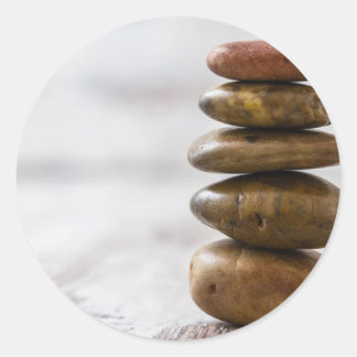 Pile of dark coloured stones on white background classic round sticker