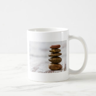 Pile of dark coloured stones on white background coffee mug