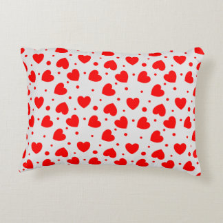 Pillow with red hearts on white background
