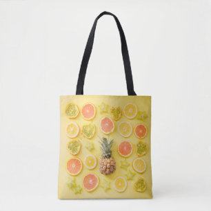 Pineapple surrounded by citrus fruits tote bag