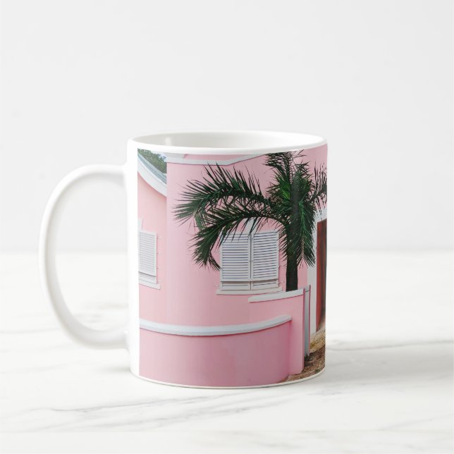 Pink and white concrete house near green trees und coffee mug (Left)