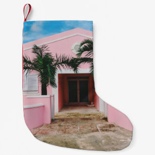Pink and white concrete house near green trees und small christmas stocking