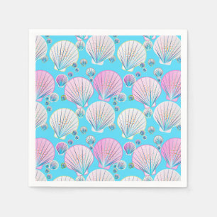 Pink and white sea shells on turquoise napkin