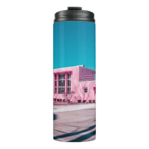 Pink concrete building under clear blue sky thermal tumbler