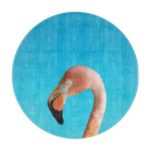 Pink flamingo face against blue water on a cutting board
