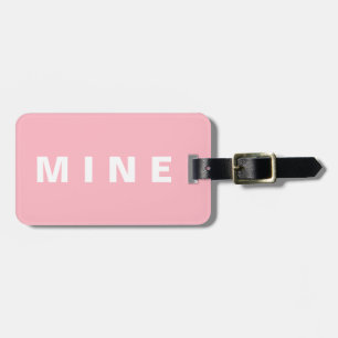 Pink luggage tag with 'Mine' written on it