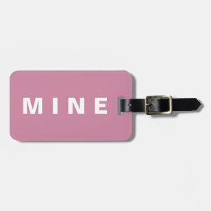 Pink luggage tag with 'Mine' written on it