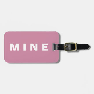 Pink luggage tag with 'Mine' written on it