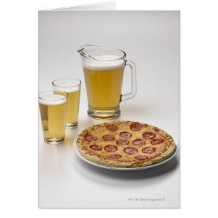 Pitcher and two pints of beer beside pepperoni