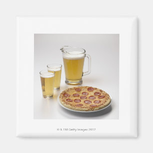 Pitcher and two pints of beer beside pepperoni magnet