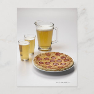 Pitcher and two pints of beer beside pepperoni postcard