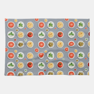 Plates of tomato basil and pasta on a gray tea towel