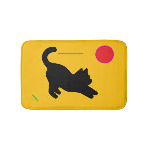 Playful Black Cat on Yellow Bath Mat