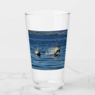 Playful Common Dolphins Porpoising Through Ocean  Glass