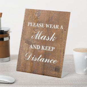 Please wear a mask wood background pedestal sign