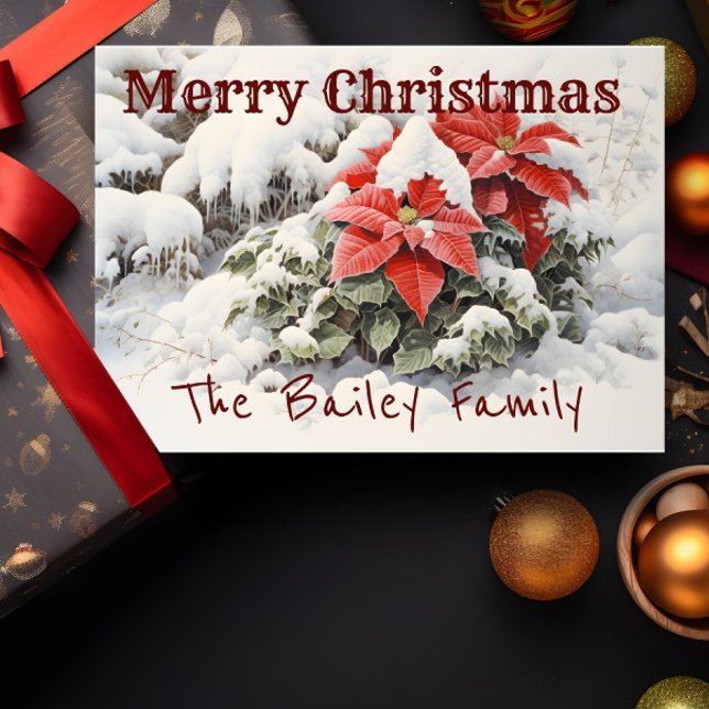 Poinsettia Merry Christmas  Card (A Christmas card depicting red poinsettias in the snow is shown with a present and decorations.)