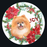 Pomeranian Dog Joy Poinsettia Christmas Wreath Classic Round Sticker<br><div class="desc">On this sticker,  an adorable little Pomeranian dog peeks out of a red poinsettia and green holly Christmas wreath. At one side is red text that says "JOY". Cute for your Holiday correspondence or gift packages.</div>