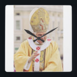 Pope Benedict XVI The Teacher of Truth Square Wall Clock<br><div class="desc">Elevate your space with the serene and scholarly presence of Pope Benedict XVI. This high-fidelity reproduction portrays the Pope in a moment of prayerful reflection, embodying the "humble worker in the vineyard of the Lord." The composition highlights the dignity of the papacy and the personal warmth of Joseph Ratzinger, known...</div>