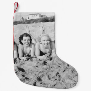 Portrait of five young women lying on the beach an small christmas stocking
