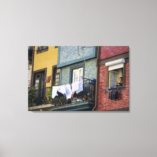 Portugal, Oporto (Porto). Woman hanging laundry Canvas Print (Front)