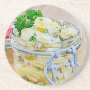 Potato salad in a jar on wooden coaster