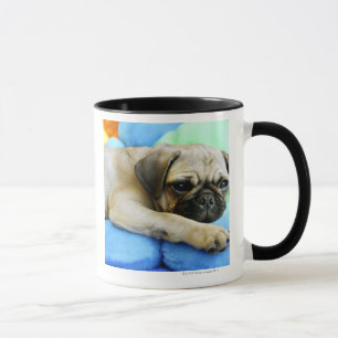 Pug laying on pillows mug