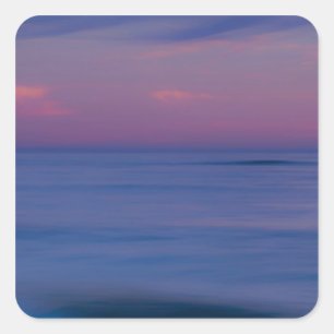 Purple-coloured sunrise on ocean shore square sticker