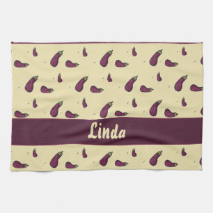 Purple eggplants on yellow tea towel