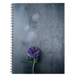 Purple petaled flower on grey surface notebook