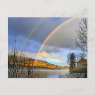 Rainbow over lake and house after storm postcard