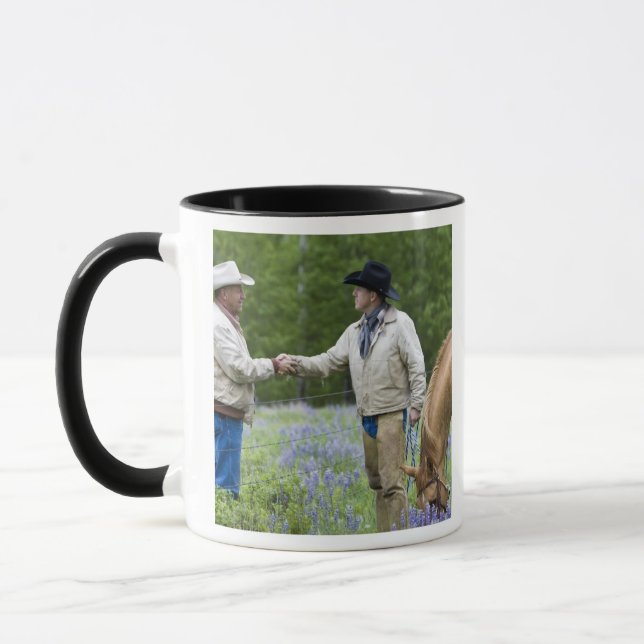 Ranchers shaking hands across the fencing in mug (Left)