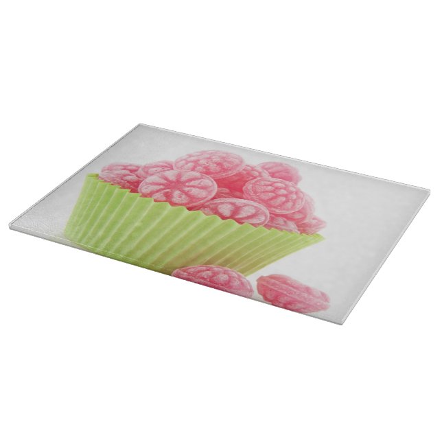 Raspberry tasty candy sweets in green cup cake cutting board (Corner)