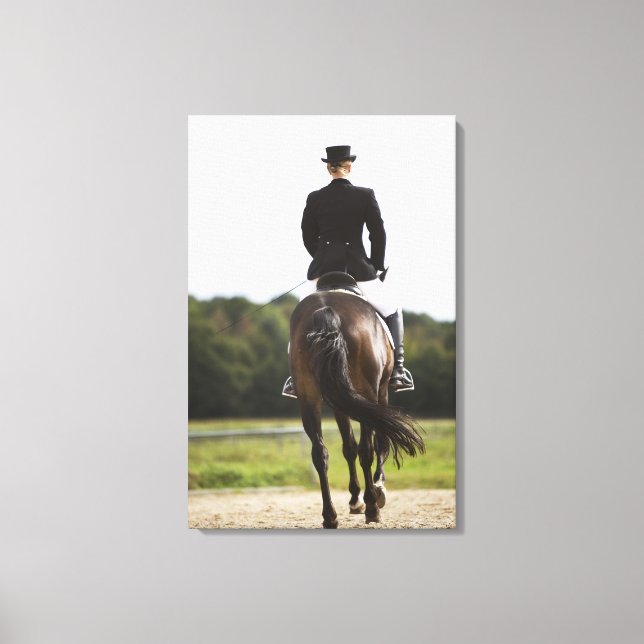 rear view of female dressage rider exercising canvas print (Front)