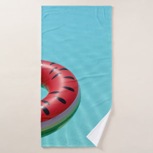 Red and green lifebuoy on swimming pool bath towel