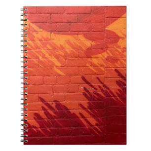 Red and orange painted brick wall notebook