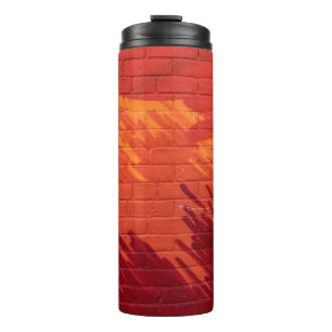Red and orange painted brick wall thermal tumbler