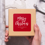 Red and White Brush Script Merry Christmas Square Sticker<br><div class="desc">Modern holiday stickers featuring "Merry Christmas" displayed in white brush script lettering with a red background. Personalize the simple Merry Christmas stickers with your name and year in white lettering. The red Christmas stickers are perfect for sealing holiday envelopes,  party favor bags,  and gifts.</div>