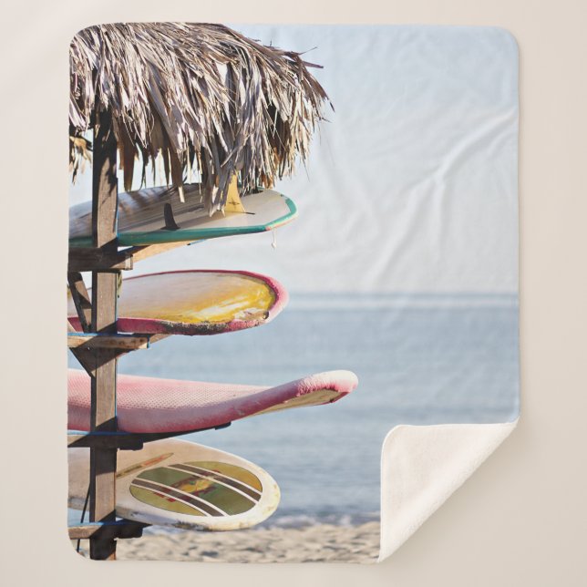 Red and white surfboard in brown wooden rack sherpa blanket (Front)