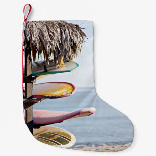 Red and white surfboard in brown wooden rack small christmas stocking