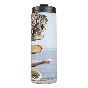 Red and white surfboard in brown wooden rack thermal tumbler