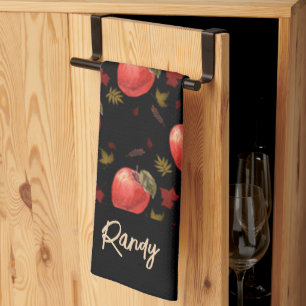 Red apples and leaves on black tea towel