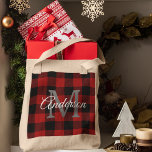Red Buffalo Plaid | Personal Initial | Gift Tote Bag<br><div class="desc">Carry your holiday cheer in style with this Red Buffalo Plaid Personalized Tote Bag, featuring your family name and monogram in a timeless rustic design. The warm red-and-black buffalo check pattern gives it that cozy farmhouse feel, perfect for winter outings, Christmas shopping, or festive gift-giving. Made from durable, eco-friendly fabric,...</div>