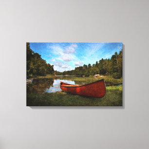 Red canoe on the lake bank canvas print