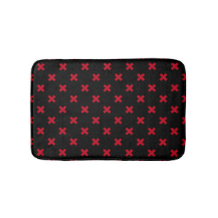 Red cross stitches on black bath mat