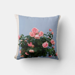 Red flowers with green leaves on blue wall cushion