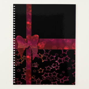 Red glitter bow and stars on black planner