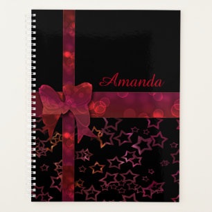 Red glitter bow and stars on black planner