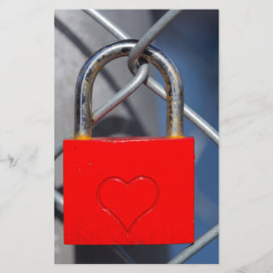 Red heart lock on fence stationery