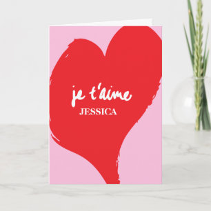 Red heart with je t’aime-text on pink background card