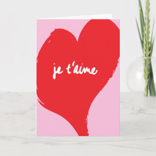 Red heart with je t’aime-text on pink background card